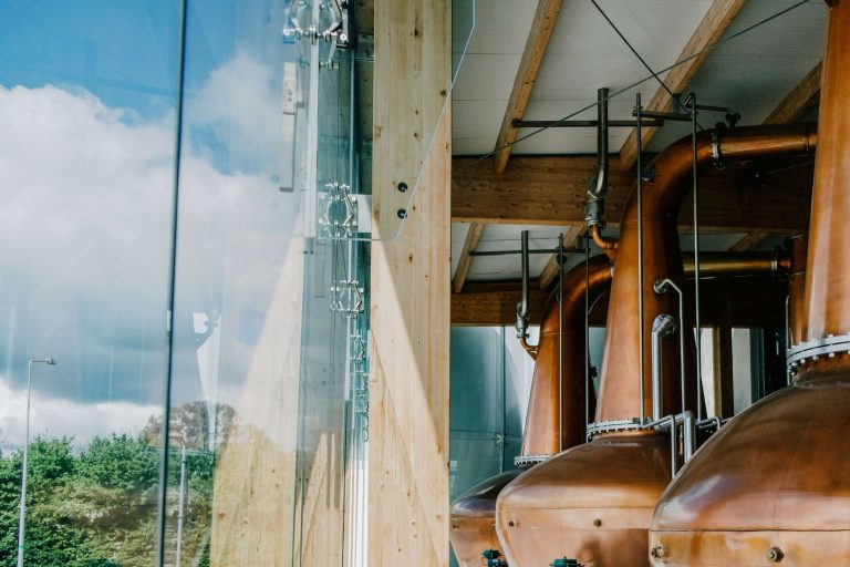 Copper pot stills beside a large window